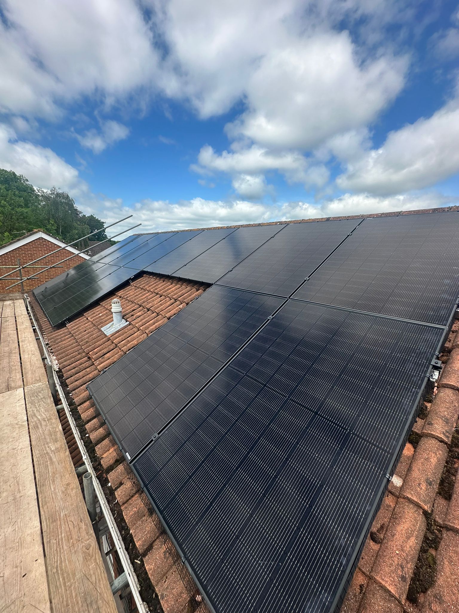 All black Jinko solar panels installed on a concrete tile roof.