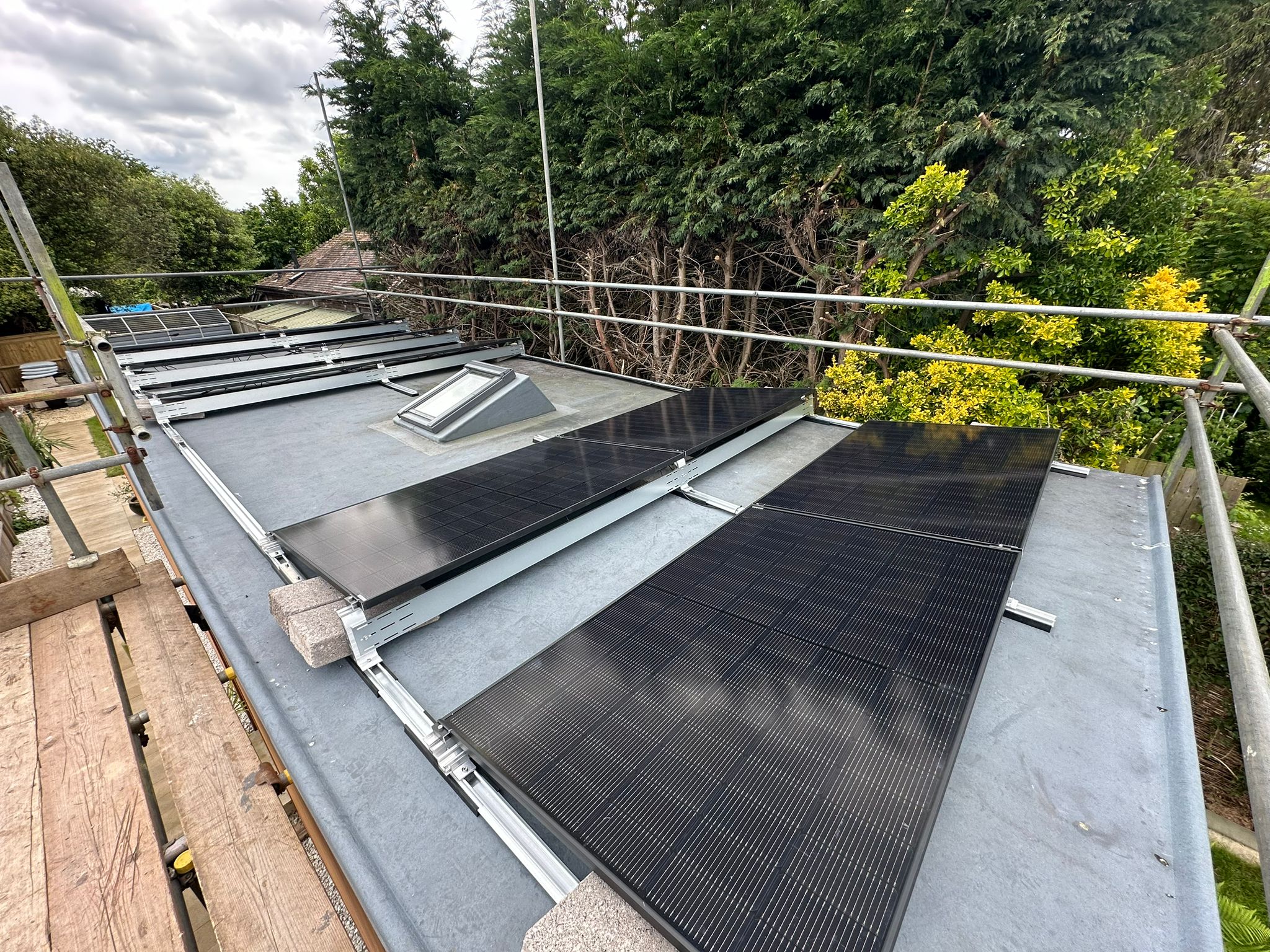 All black Jinko solar panels installed on a flat roof.